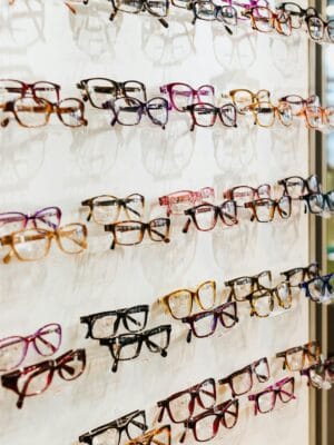 Colorful eyeglasses on display in a modern, well-lit eyewear store.