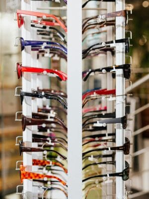 Vibrant array of eyeglasses on a display rack in a modern optical store.