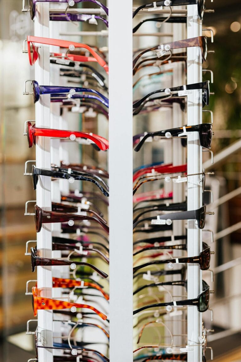 Vibrant array of eyeglasses on a display rack in a modern optical store.